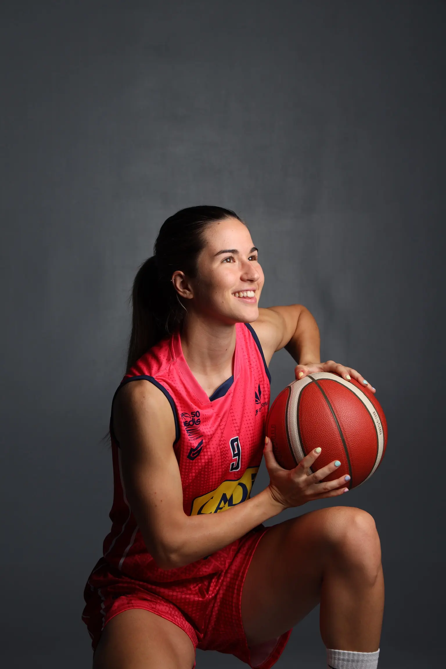 Laura Peña smiling with a basketball, wearing a Cadí La Seu jersey